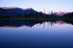 Sunset over Vermilion Lakes in Banff, Alberta with mountain reflections.
